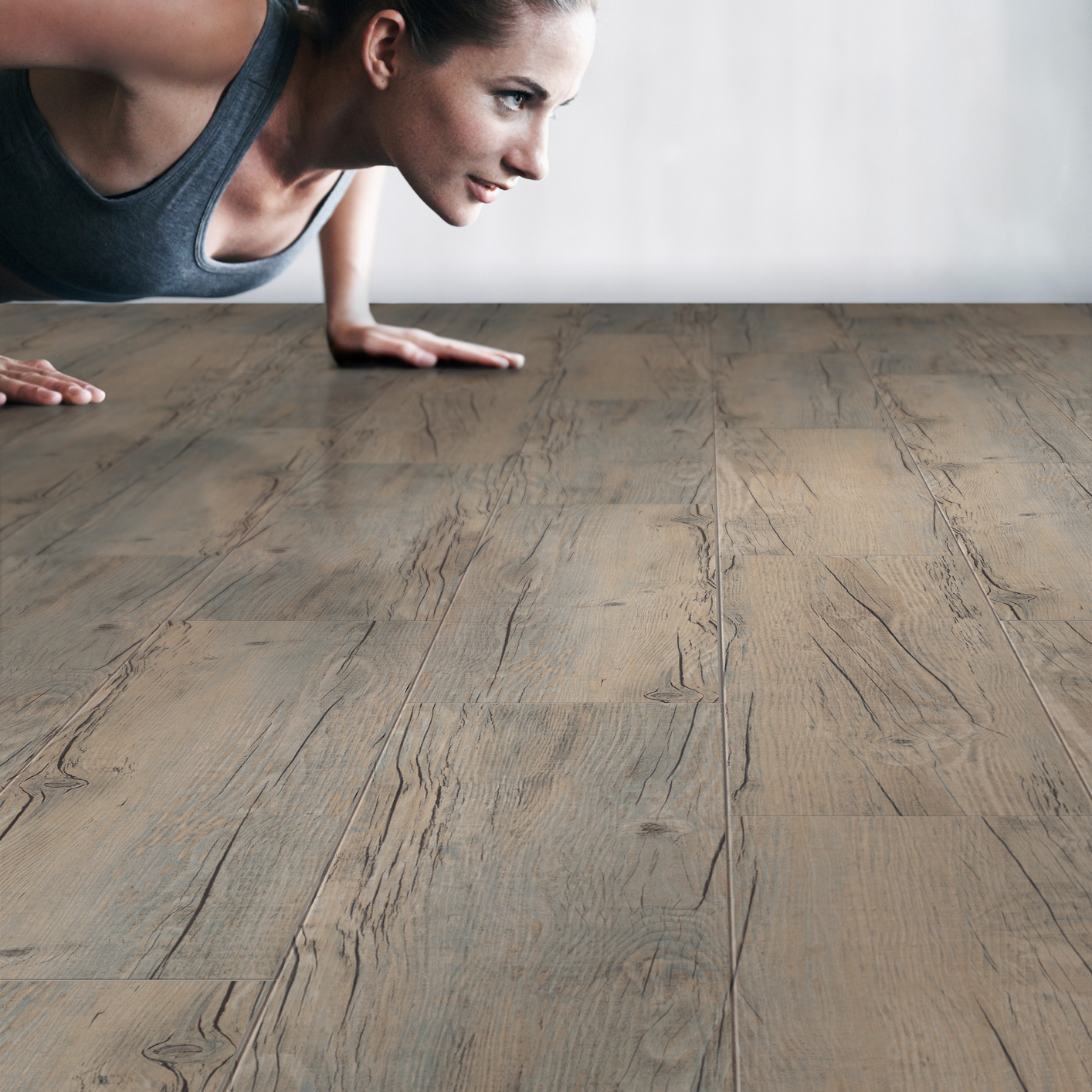 Jeune femme faisant du sport sur du sol vinyle à coller Kalinafloor Temp 55 10 chêne foncé