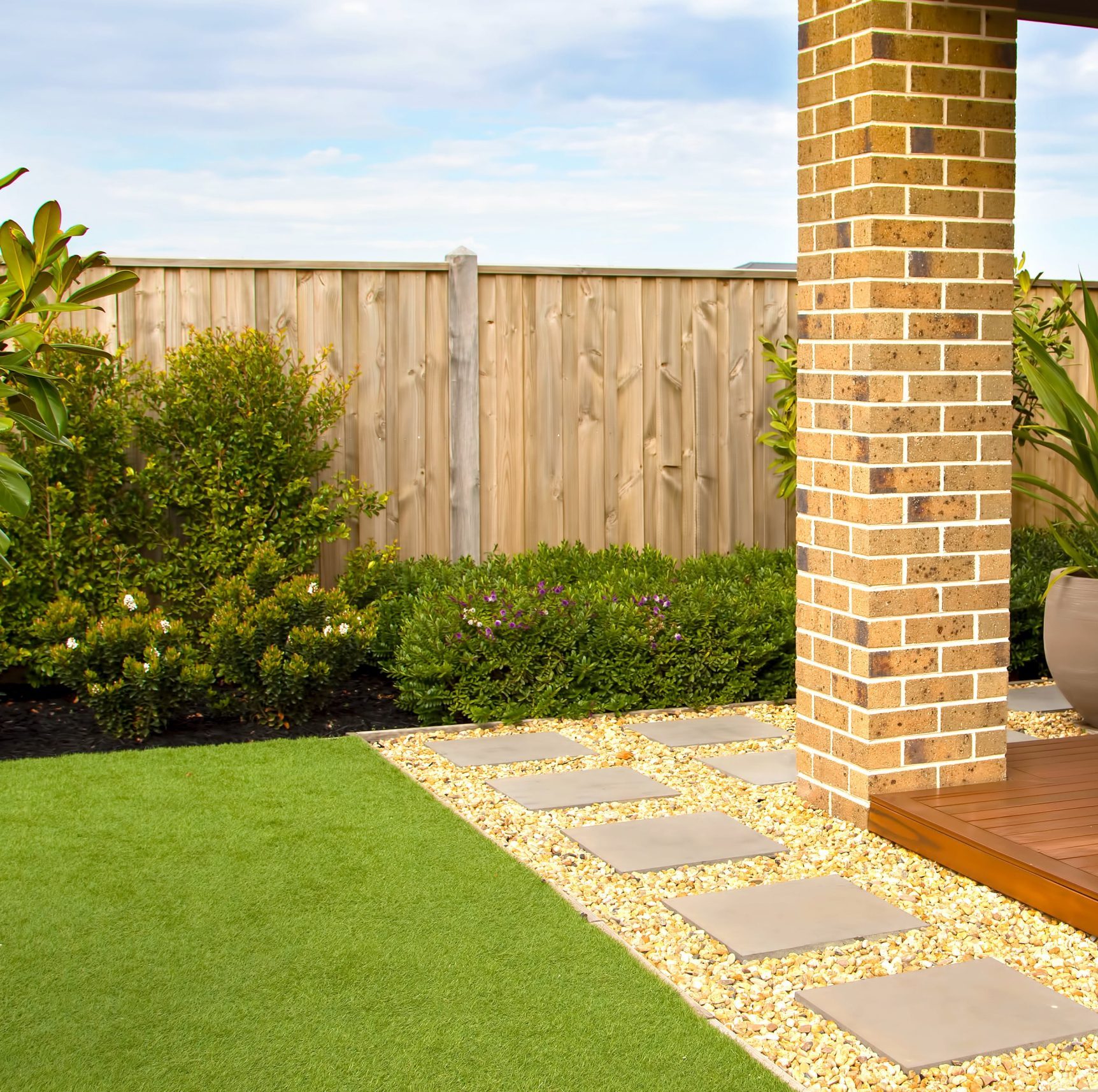 Terrasse bois avec gazon synthetique-min jardin avec terrasse en bois, pilier en briques et gazon synthétique réaliste